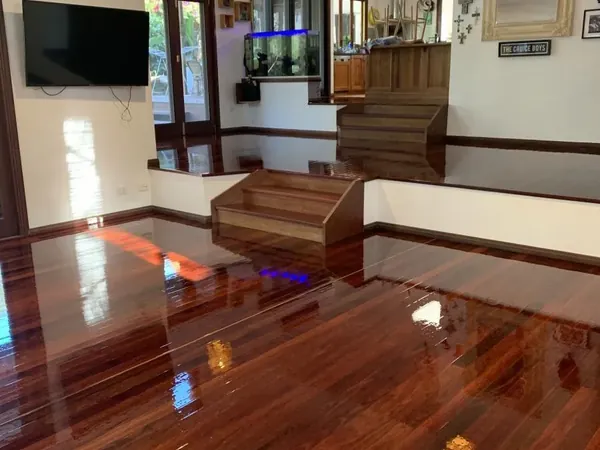 Polished timber living room floor with timber steps leading to the kitchen