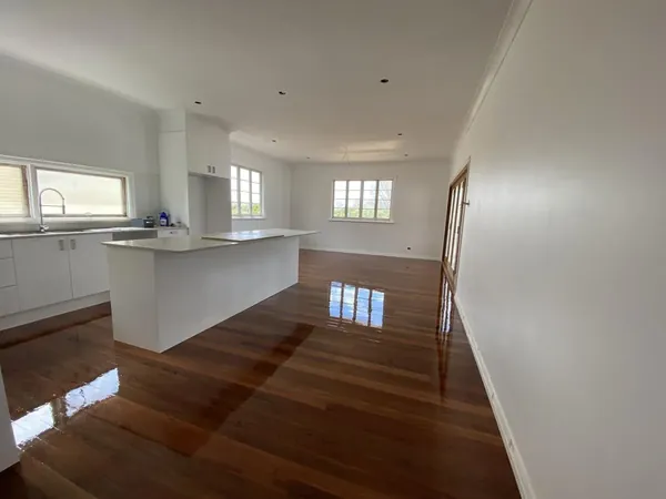 Polished timber floor through an open-plan kitchen and living area