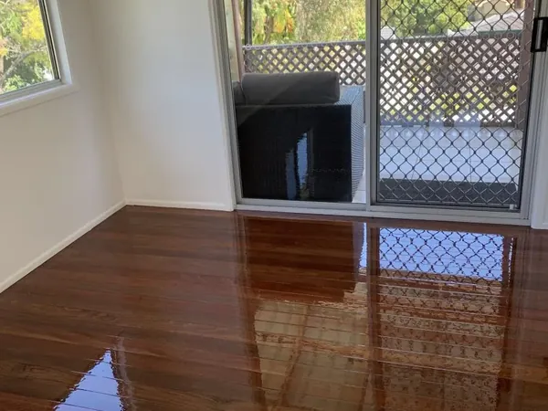 Polished brown floorboards beside glass doors opening to the garden