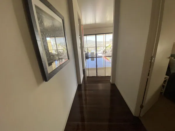 Dark timber floor in an entry hallway leading to glass doors
