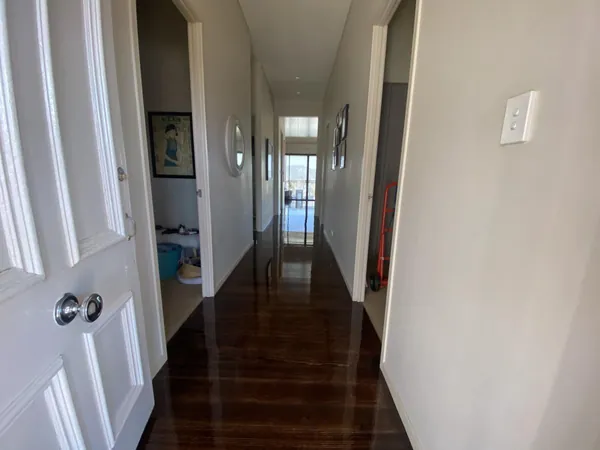 Dark timber floor along a hallway lined with white doors