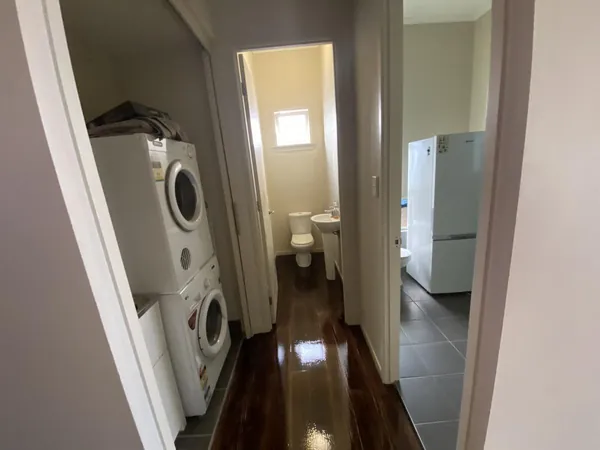 Dark finished floorboards through a laundry with a washing machine