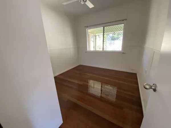Polished timber floor in a small bedroom viewed through its doorway