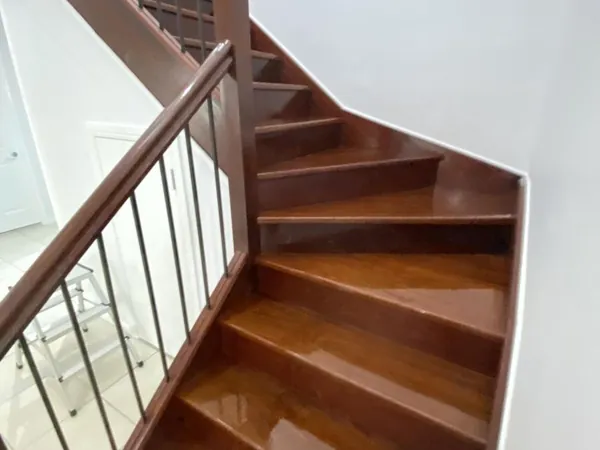 Polished timber stairs turning around a landing with timber handrails