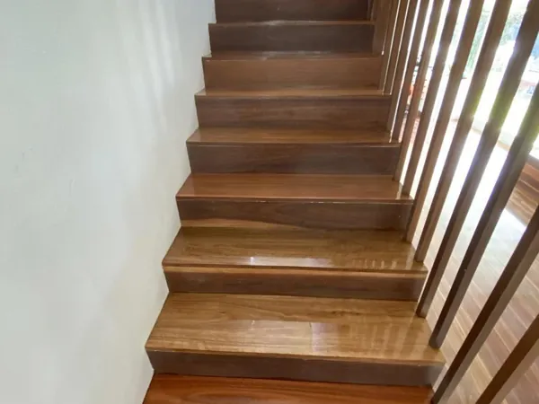 Finished timber staircase with a timber balustrade and white walls