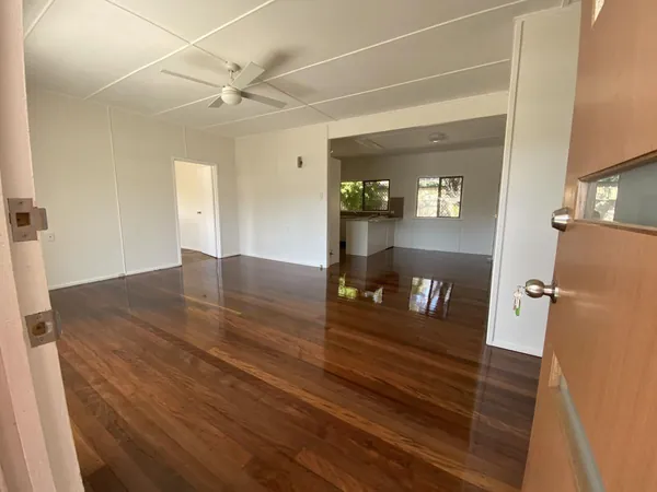 Polished timber floor through an open living area with a ceiling fan