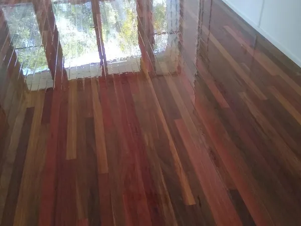 Polished reddish floorboards leading towards glass garden doors