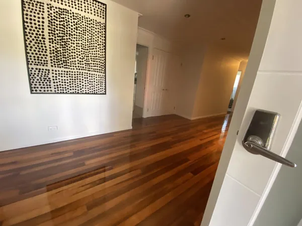 Polished timber flooring in a hallway beside framed wall artwork