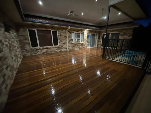 Glossy timber floor in a spacious living room with exposed brick and stone walls