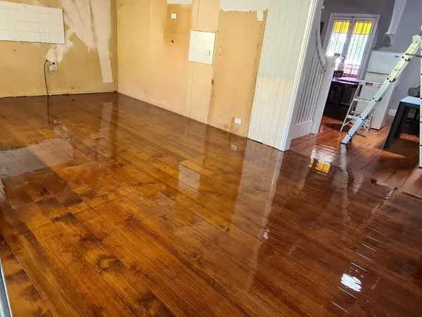 Glossy golden floorboards in a room adjoining a kitchen