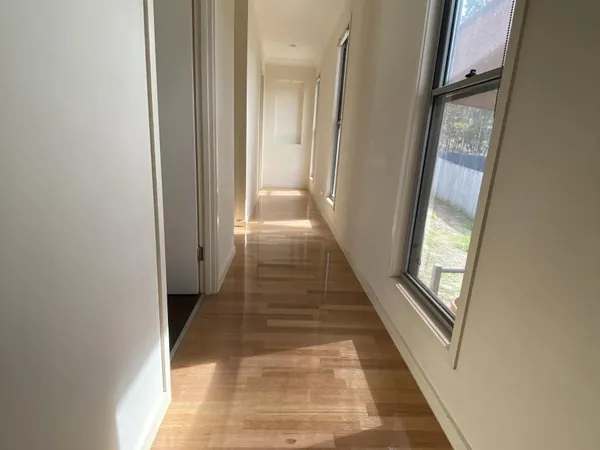Light timber floor along a bright hallway with windows on one side