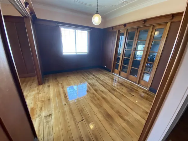 Light polished floorboards in a timber-panelled room with glass-fronted cabinets