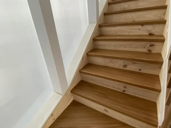 Timber staircase with white balusters and a matching wooden handrail