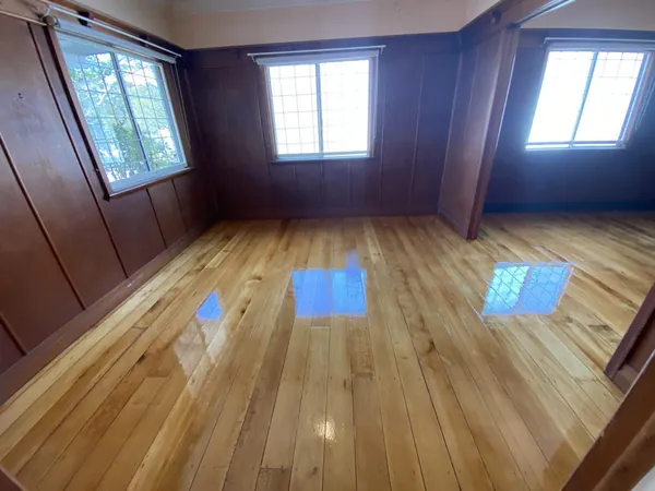 Light polished floorboards in a room with dark timber-panelled walls