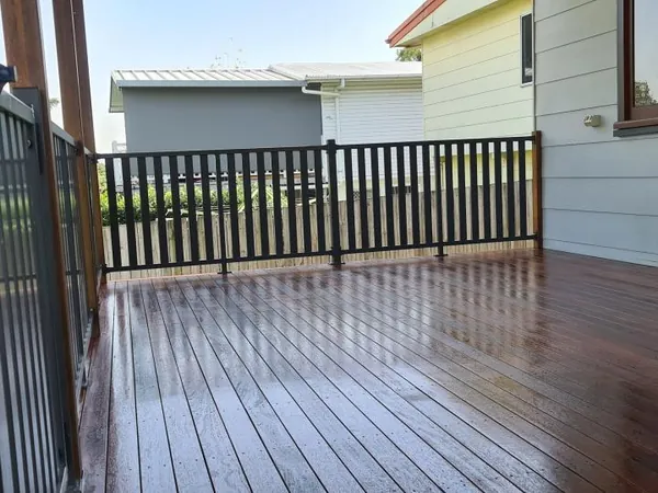 Finished covered timber deck beside a house with white weatherboards