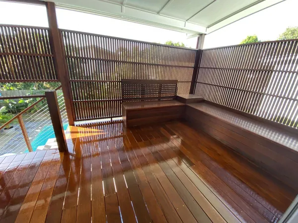 Glossy covered timber deck with built-in seating and a slatted privacy screen