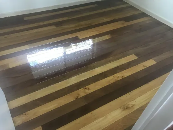 Close-up of contrasting light and dark floorboards with a glossy finish