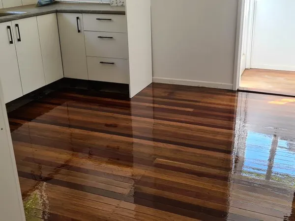 Polished timber floor connecting a white kitchen with an adjoining hallway