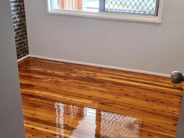 Golden timber floor with a reflective finish viewed through a doorway