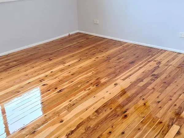 Golden polished floorboards with visible knots in an empty room