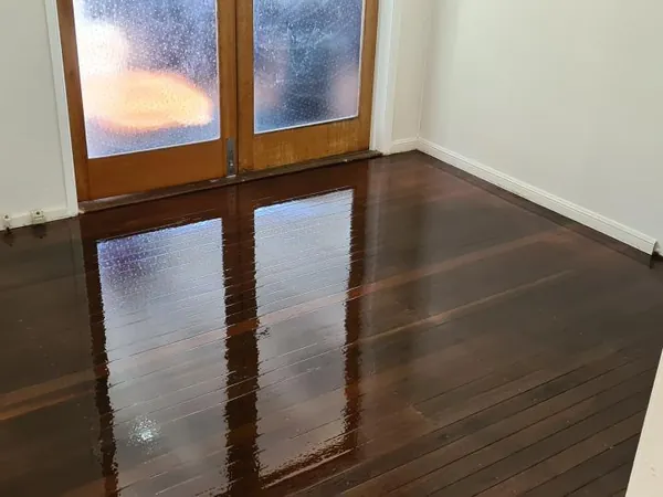 Dark polished floorboards leading to timber-framed glass doors