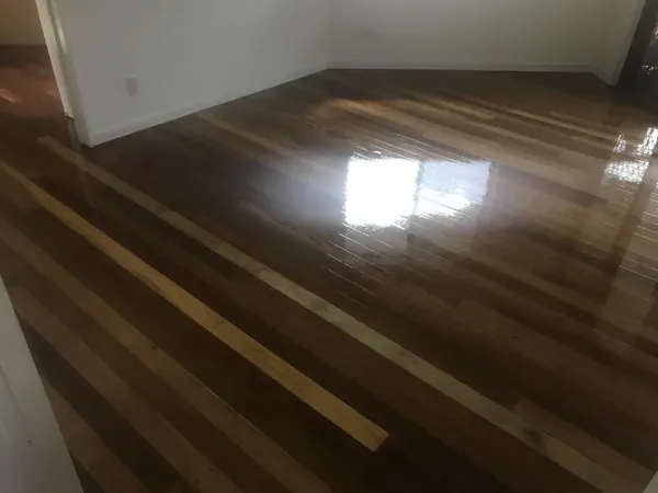 Dark finished timber boards reflecting light from a nearby window