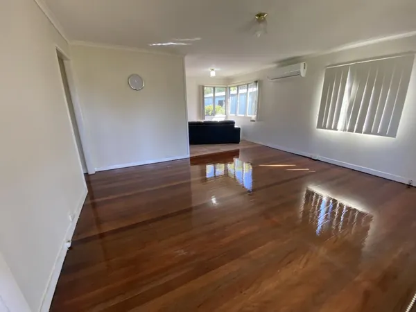 Polished brown timber floor in a spacious room with windows on two sides
